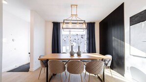 Un comedor moderno con una mesa de madera, seis sillas y una lámpara colgante.