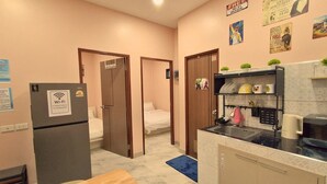 A compact hotel room with a kitchenette, a bed, and a bathroom. - 3-Min Walk to Beach • Super Private 2 BR House (Tambon Patong)