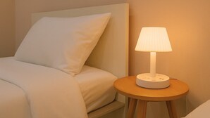 A neatly made bed with a white pillow and a bedside table with a lamp. - 3-Min Walk to Beach • Super Private 2 BR House (Tambon Patong)