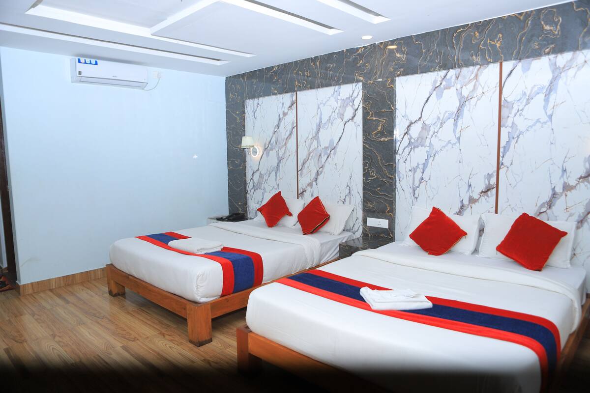 Una habitación de hotel con dos camas, paredes con diseño de mármol y suelo de madera.