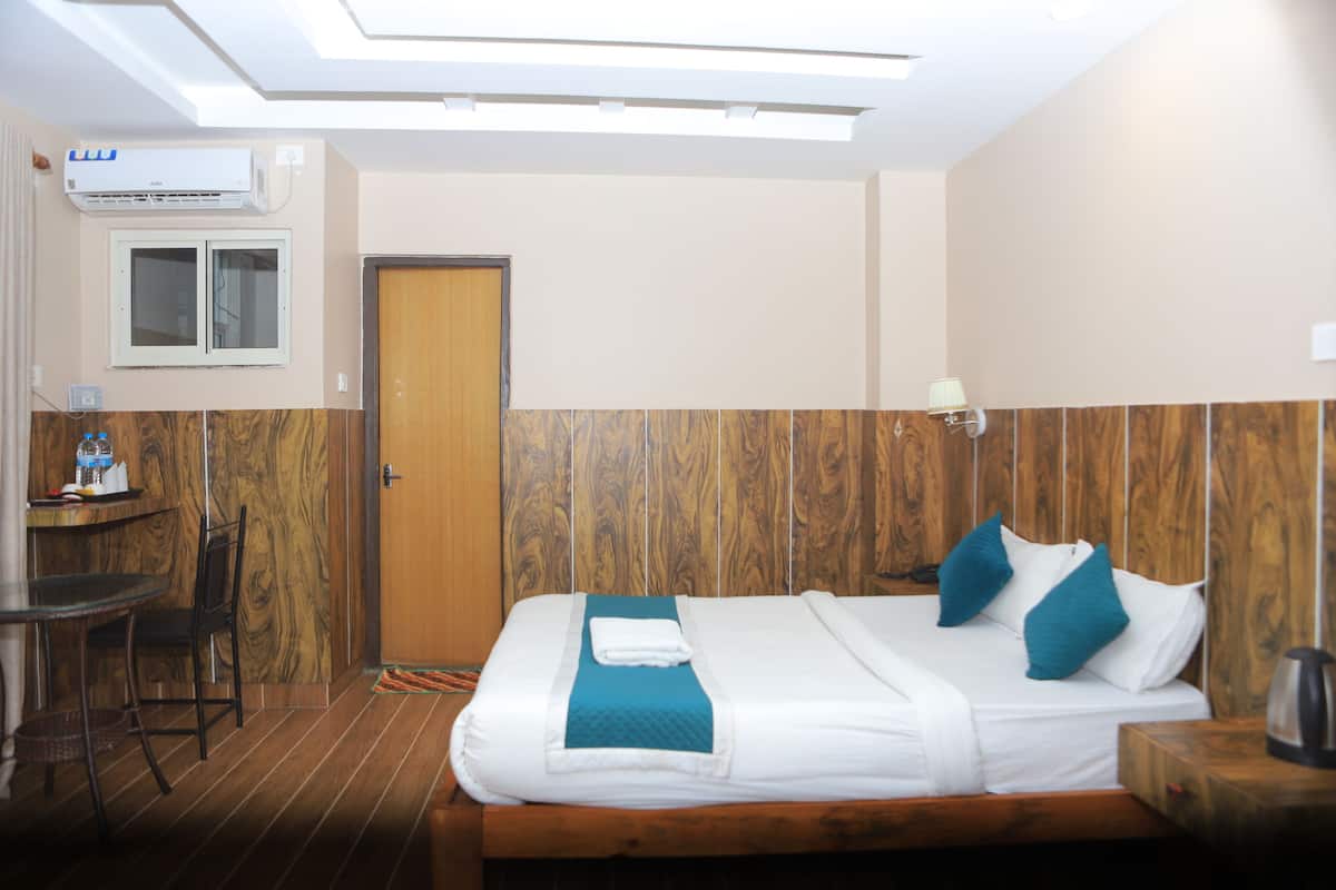 Una habitación de hotel con una cama, un escritorio, una silla y una ventana.