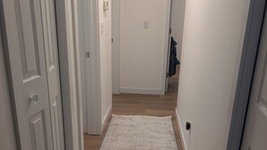 A narrow hallway with white doors and a beige carpet.