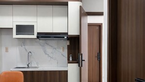 Una cucina moderna con forno a microonde integrato, lavello in acciaio inossidabile e pensile in legno.