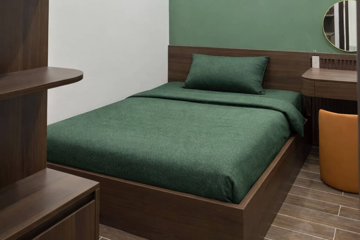 Un dormitorio moderno con cama, escritorio y silla.