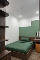 Un dormitorio moderno con cama, escritorio y silla.