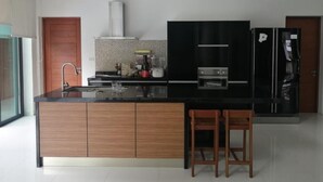A modern kitchen with a central island, built-in oven, and stainless steel appliances.