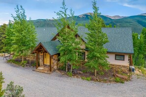 A lodge with a stone facade, wooden porch, and a view of mountains. - Luxurious retreat with grand views of Twin Lakes and the Sawatch Mountain Range (Twin Lakes)