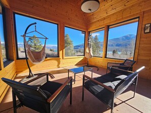 A wooden cabin with large windows offering mountain views, a hammock, and two lounge chairs. - Luxurious retreat with grand views of Twin Lakes and the Sawatch Mountain Range (Twin Lakes)