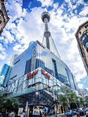 Ein modernes Hotel mit markantem Turm, großen Glasfenstern und einem gut sichtbaren Schild mit der Aufschrift 'Westfield'.