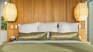 A bed with a wooden headboard, white pillows, and a green blanket.