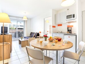 Ein modernes Hotelzimmer mit Essbereich, Küchenzeile und Blick ins Freie.
