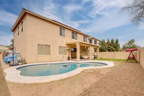 Une maison à deux étages avec une piscine dans le jardin.