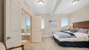 Una camera da letto con un letto, una sedia, una porta, una finestra e una luce a soffitto.