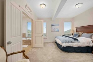 A bedroom with a bed, a chair, a door, a window, and a ceiling light. - Trail’s End: Ocean Views, Hot Tub, Game Room & Beach Access, Pet Friendly, 2 Miles to Casino (Lincoln City)