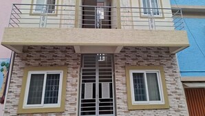 Ein mehrstöckiges Wohngebäude mit Balkon, Fenstern und einer Tür.