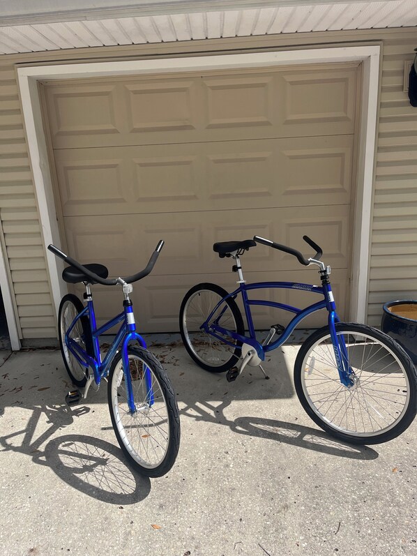 Two bicycles parked in front of a garage door.