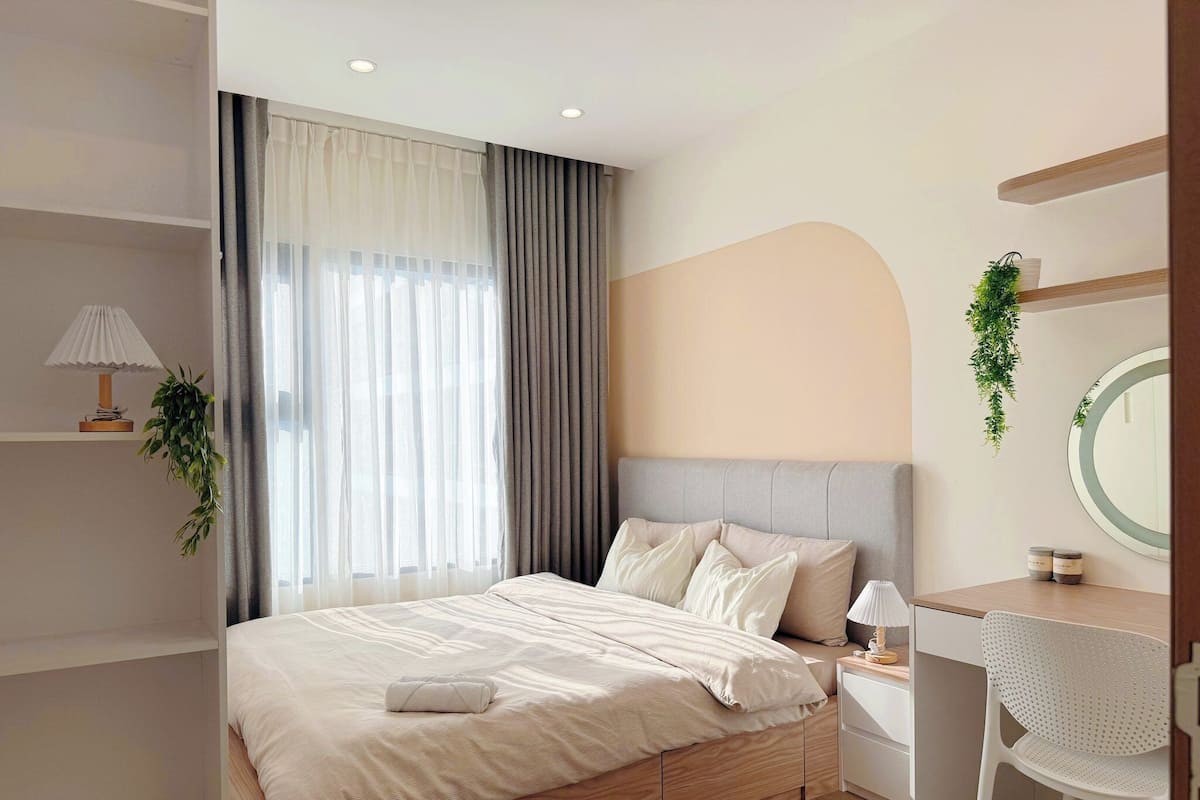 Une chambre moderne comprenant un lit, une table de chevet, une chaise et un bureau avec un miroir.