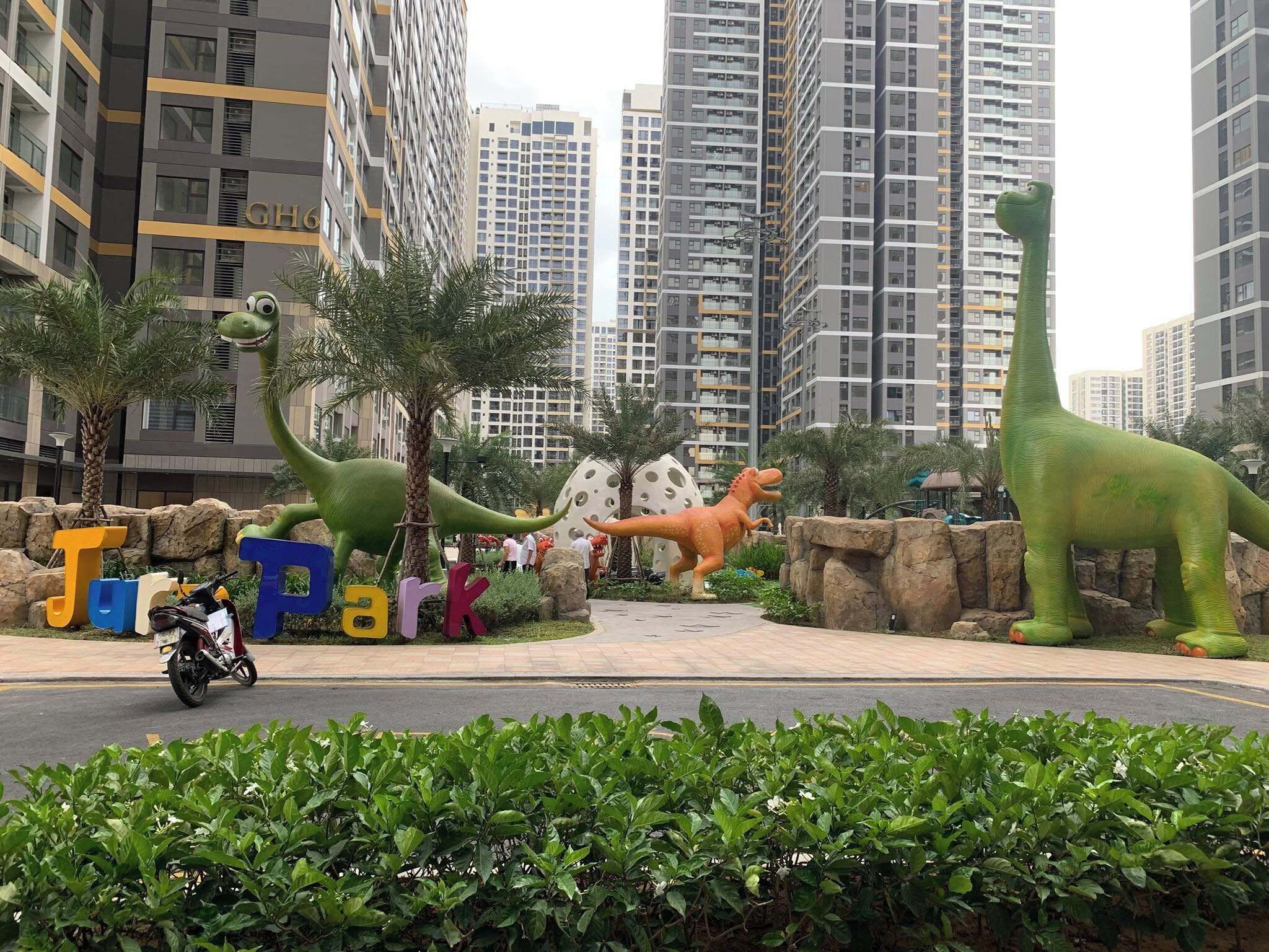 A street with a dinosaur-themed park, including a dinosaur statue and a motorcycle.