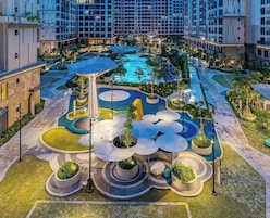 Um moderno complexo hoteleiro com piscina central, jardins ajardinados e diversas comodidades.