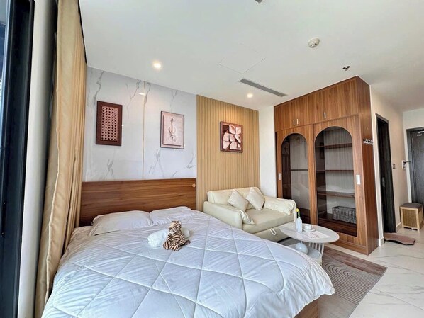 Een hotelkamer met een groot bed, een bank, een tafeltje en een kledingkast.