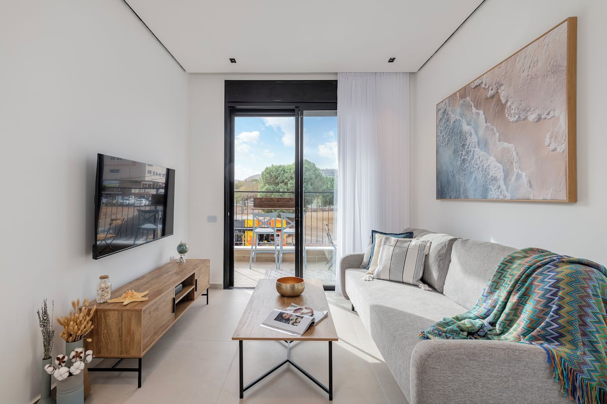 A modern living room with a sofa, coffee table, and artwork.
