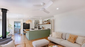 A modern living space with a kitchen, dining area, and seating area. - Luxurious & spacious retreat near Swan Lake (Sussex Inlet)