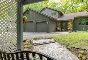 Ein zweistöckiges Haus mit Garage, steinernen Eingangsbereich und einem Garten mit Weg.