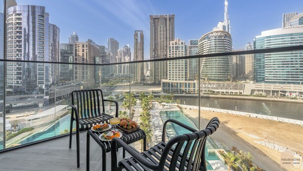 Un balcon avec vue sur la ville, comprenant une rivière et des immeubles de grande hauteur.