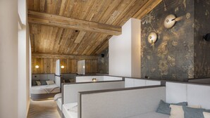 Ein modernes Zimmer mit Holzbalken, einem großen Spiegel und einer Sitzecke mit Kissen.