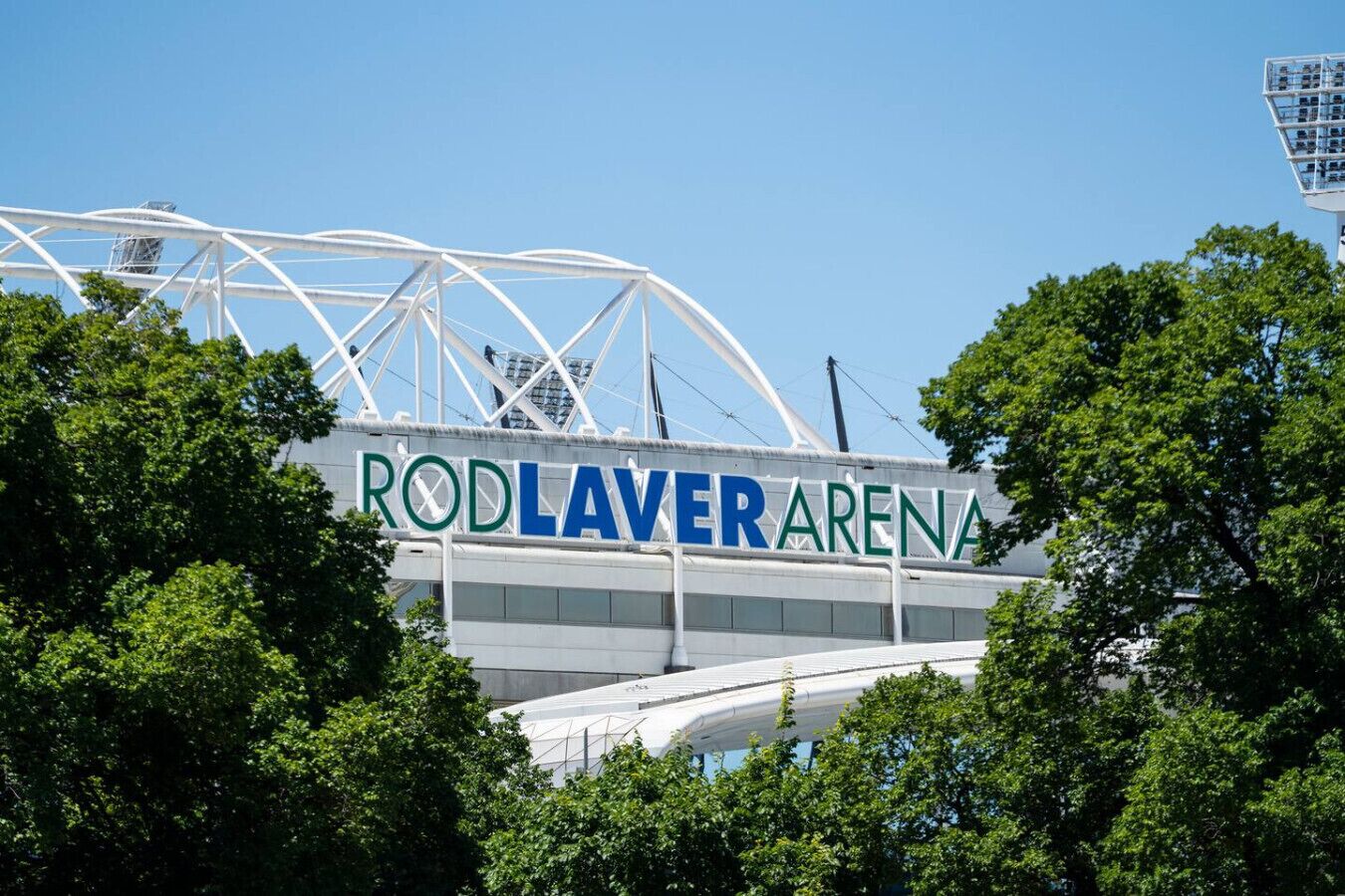 Vue extérieure de la Rod Laver Arena, offrant une vue dégagée sur la structure du stade et les arbres environnants.