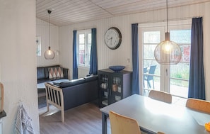 A cozy living room with a sofa, dining table, and a clock on the wall. - 3 bedroom cozy home in Nexø (Nexø)