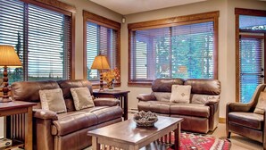 A living room with leather sofas, a coffee table, and a patterned rug. - Okanagan - Snowbanks 4 (Beaverdell)