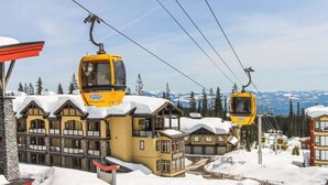 A ski resort with a large lodge and two yellow cable cars. - Okanagan - Snowbanks 4 (Beaverdell)