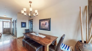 A dining area with a wooden table, benches, and a chandelier. - Okanagan - Southpoint #23 (Beaverdell)
