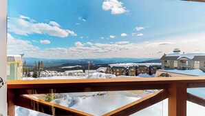 A mountain resort with snow-covered buildings and a clear sky. - Okanagan - Trappers Crossing 28 (Big White Mountain)