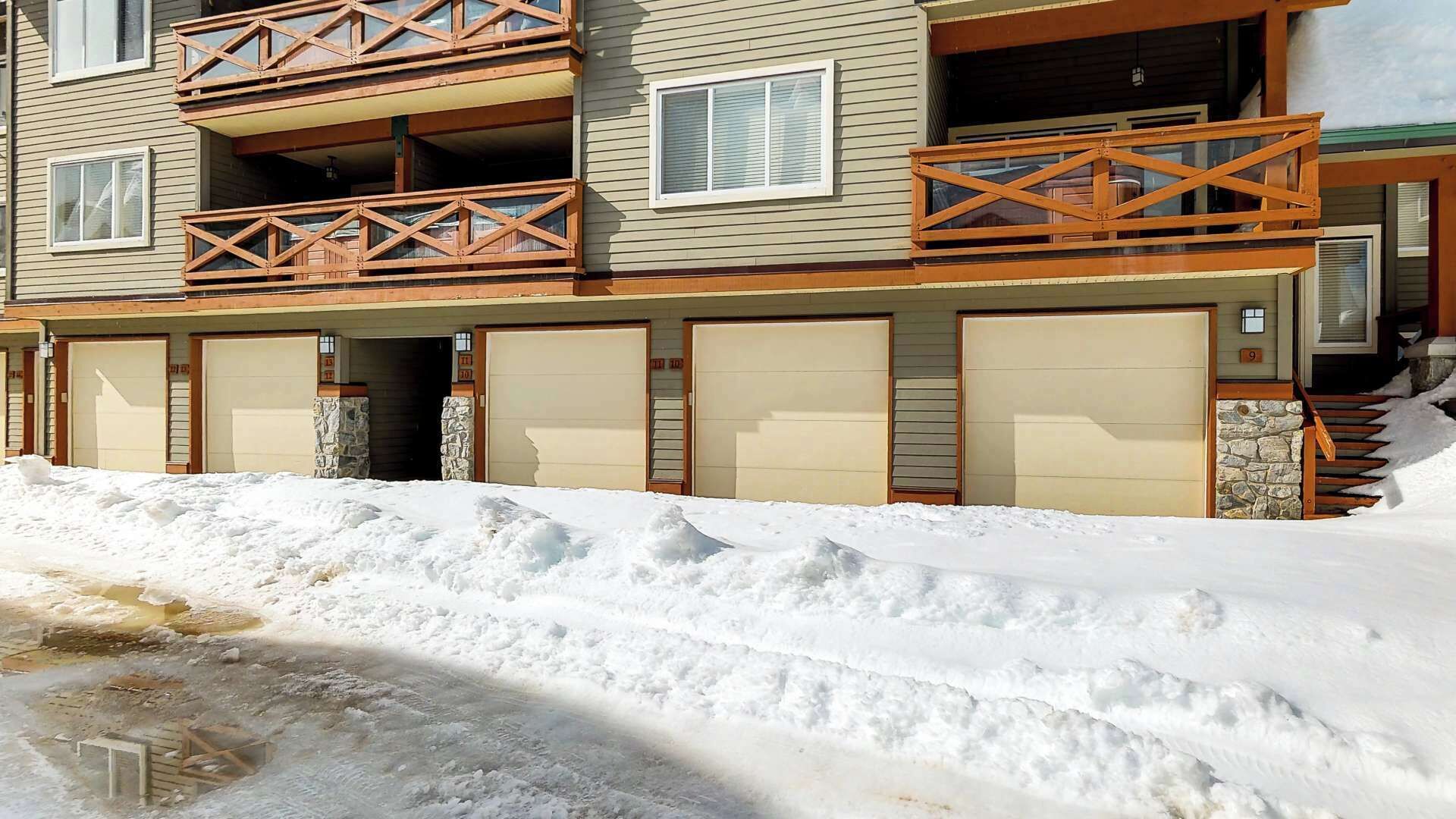 Un immeuble à plusieurs étages doté d’un balcon, d’un garage et d’une façade en pierre.