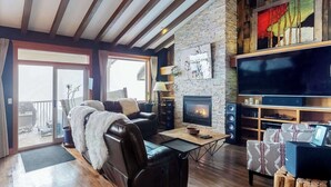 Ein gemütliches Wohnzimmer mit Kamin, Ledersofa und Flachbildfernseher.