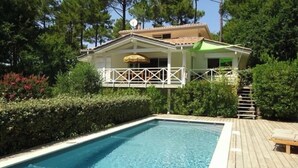 A rectangular swimming pool with a wooden deck and a white railing. - Villa 5 stars Prestige Heated pool Biscarrosse Lac Golf for 6 persons (Biscarrosse)