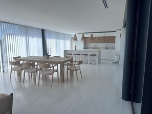 A modern kitchen with white cabinets, a central island, and bar stools.