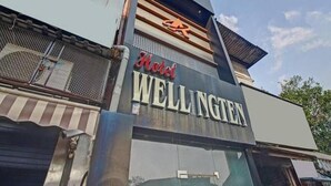 A hotel sign with the name "Hotel Wellington" and a logo above it. - Hotel Wellingten (Mumbai)