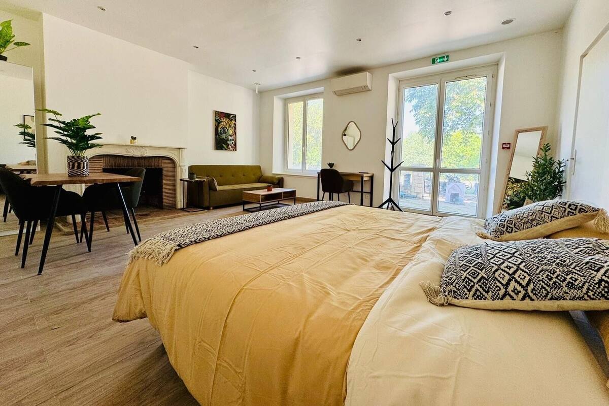 Une chambre d’hôtel moderne dotée d’un grand lit, d’un canapé, d’un coin repas et d’une cheminée.
