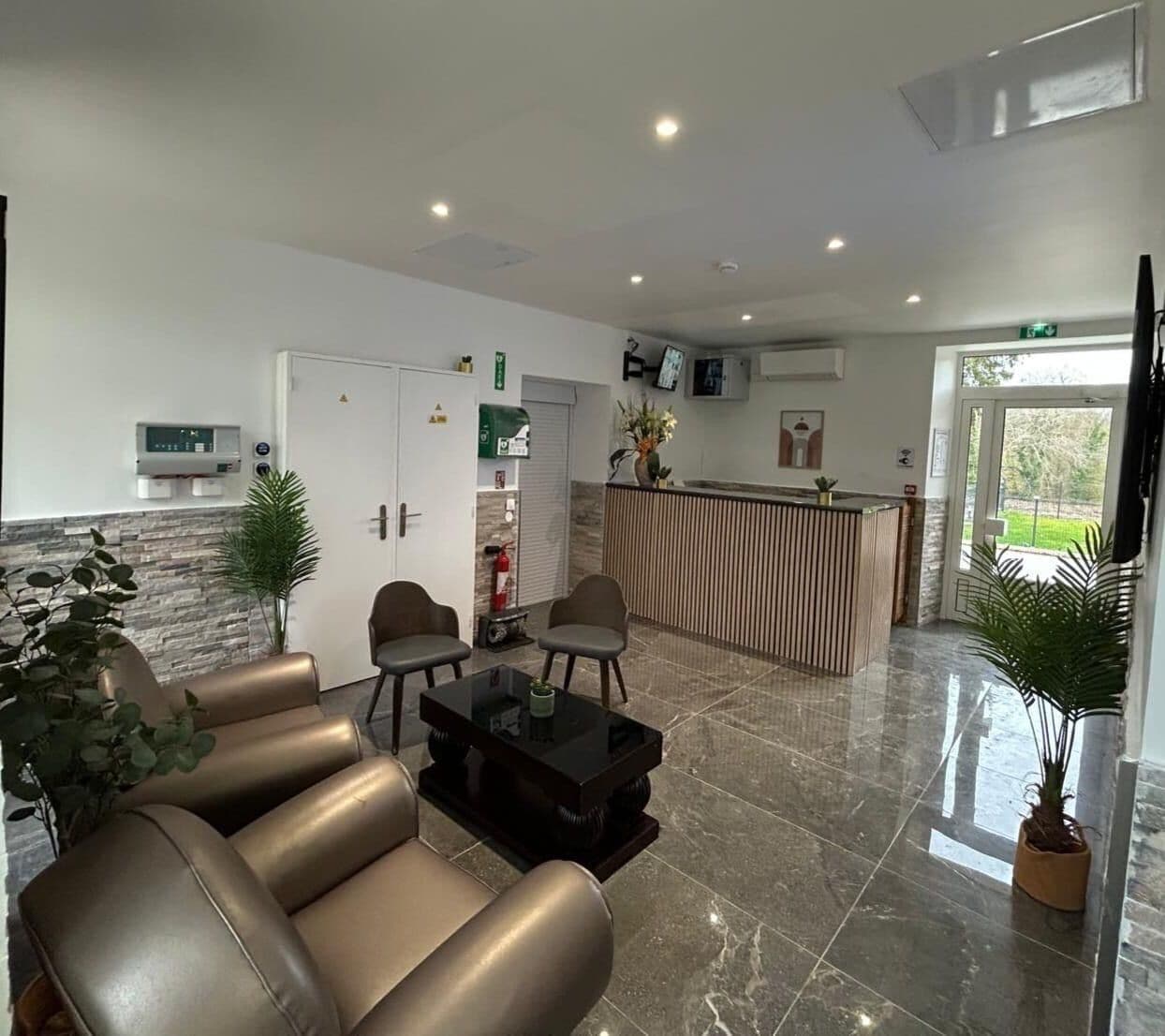 A modern lobby with leather sofas, a coffee table, and a reception desk.