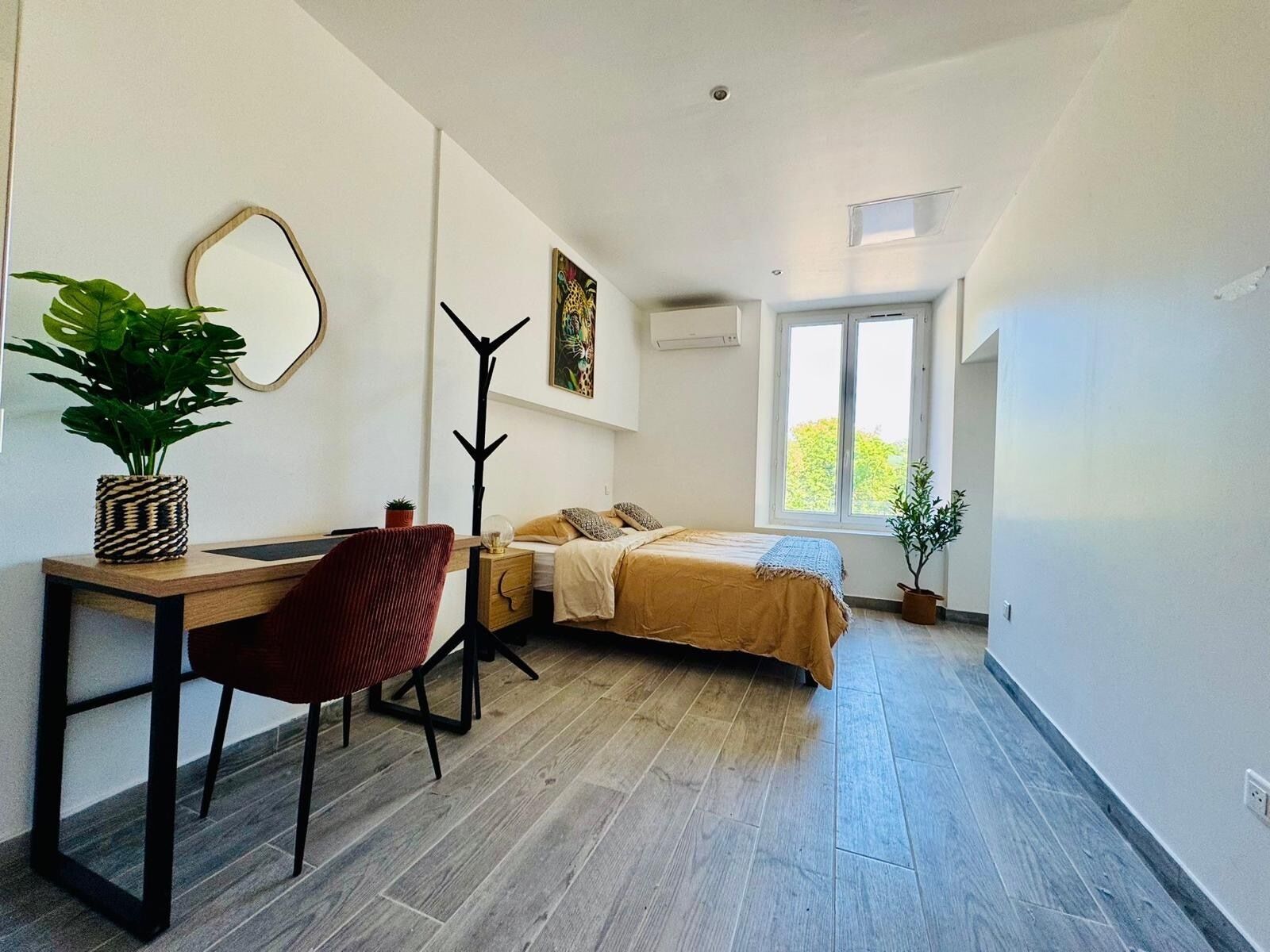 Une chambre à coucher moderne, avec un lit, un bureau, une chaise et une grande fenêtre.