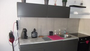 A modern kitchen with a built-in sink, a kettle, and a coffee maker.