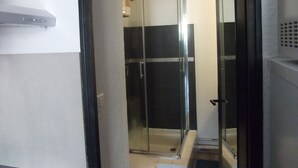 A modern bathroom with a glass shower enclosure, a toilet, and a sink.