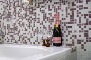 Eine Flasche Moët & Chandon Champagner auf einer Badezimmerablage mit einem gefliesten Mosaik-Schild.