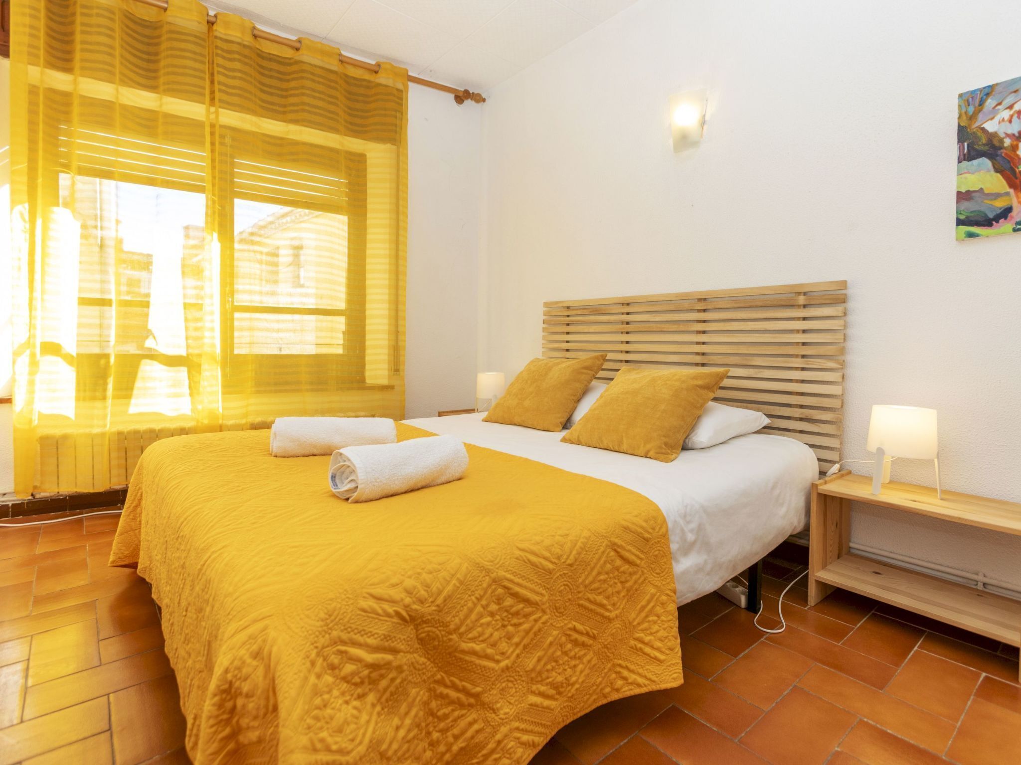 Une chambre d’hôtel avec un lit, une table de chevet, une lampe et un tableau au mur.