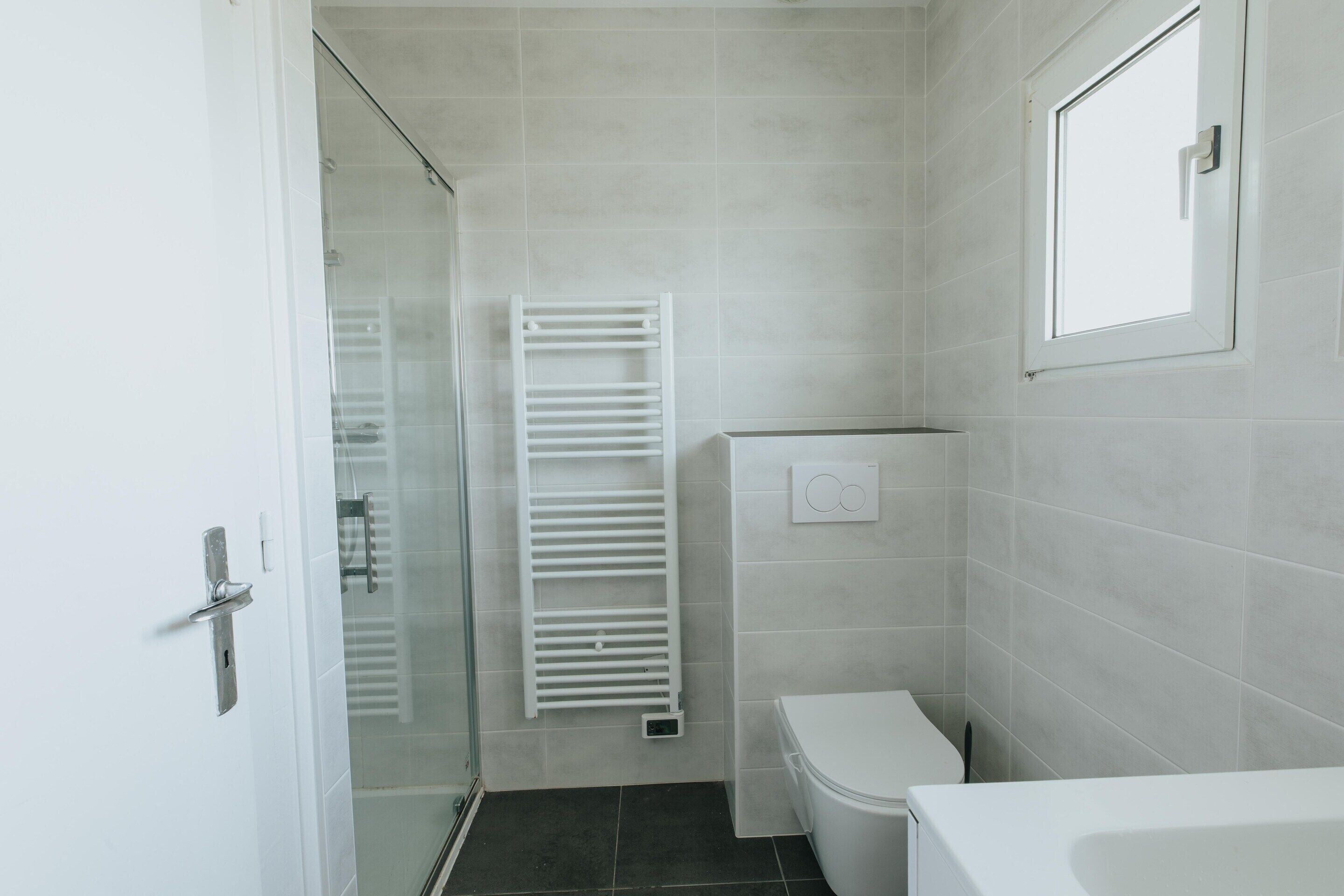 Een badkamer met een toilet, een douche en een bad.