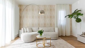 A modern living room with a beige sofa, a round coffee table, and a pendant light. - NEW Bright 36 with garden [Treviso - Venice]. (Treviso)