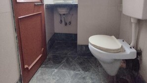 Un baño pequeño con inodoro, lavamanos y espejo.